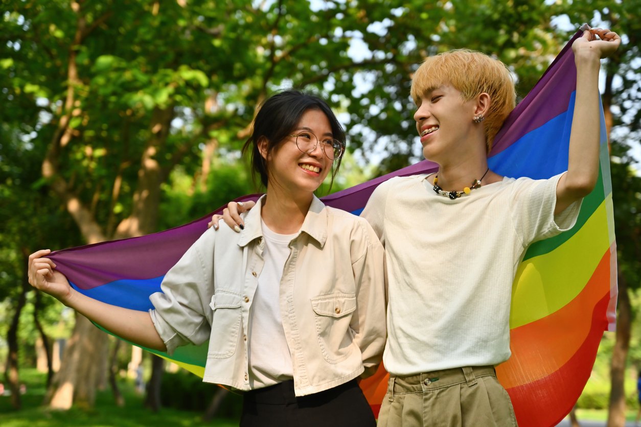 LGBT members holding a pride flag together.