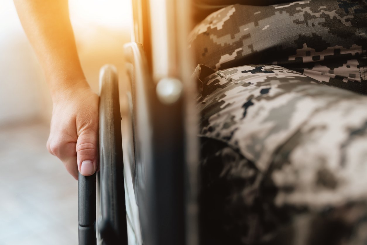 Veteran in military uniform in a wheelchair.