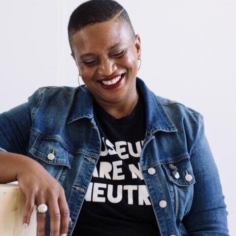 Jonell Logan, Board Secretary. A Black woman with short hair and wearing a denim jacket looks off to the side and smiles.