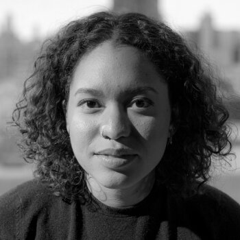 Leila Tamari, Board Member. A black and white photo of a young Black woman softly gazing forward. 